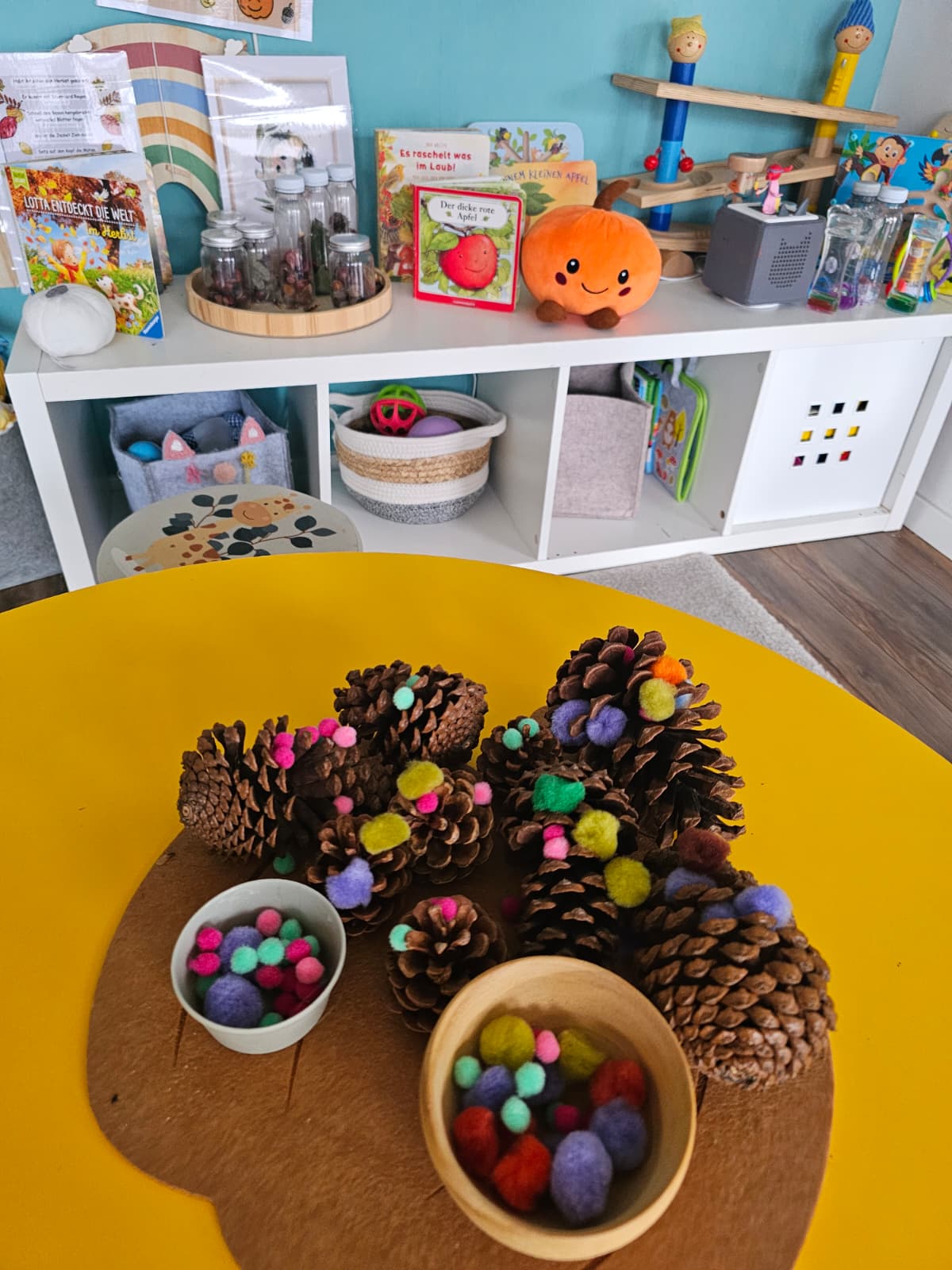 Basteln mit Tannenzapfen und bunten Pompons